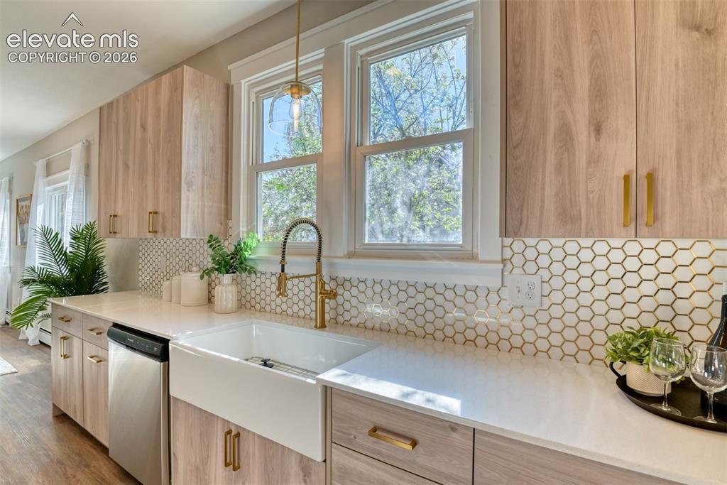 Image 19 of 47: Modern kitchen featuring wood-finish cabinetry, white countertops, and a wh