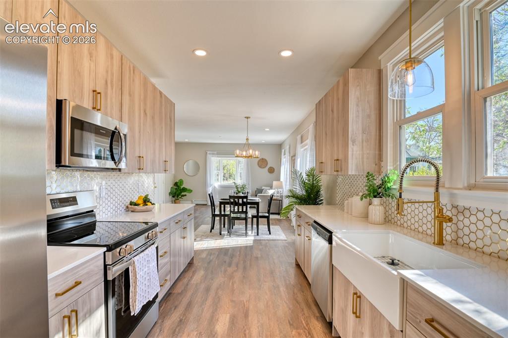 Image 21 of 47: Galley kitchen featuring wood-finish cabinetry, stainless steel appliances,