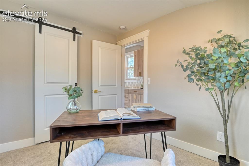 Image 25 of 47: Interior room with barn door access, neutral wall paint, and white trim