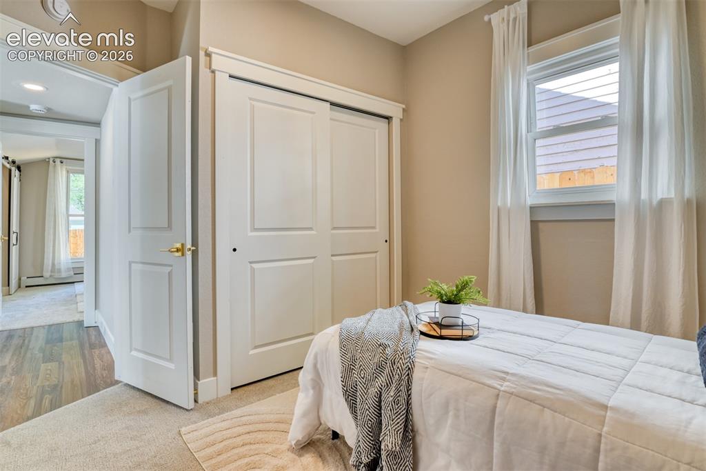 Image 28 of 47: Bedroom featuring light-toned carpeting, a window with white trim, and a wh