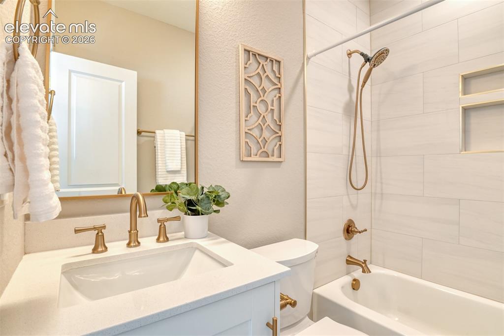 Image 31 of 47: Bathroom featuring a white vanity with an integrated sink and light-toned c