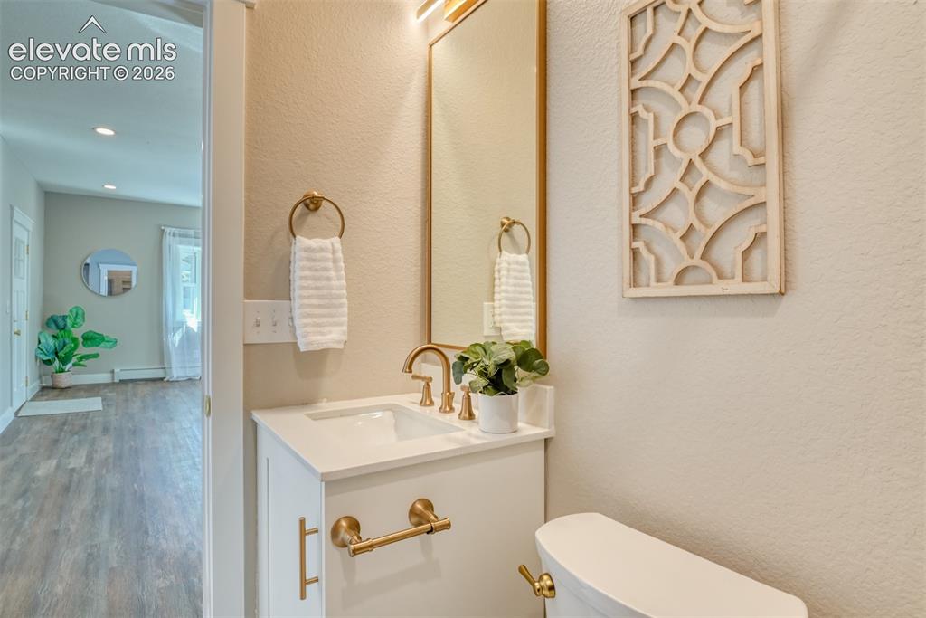 Image 32 of 47: Bathroom vanity featuring a white countertop, brass-finish faucet, and coor