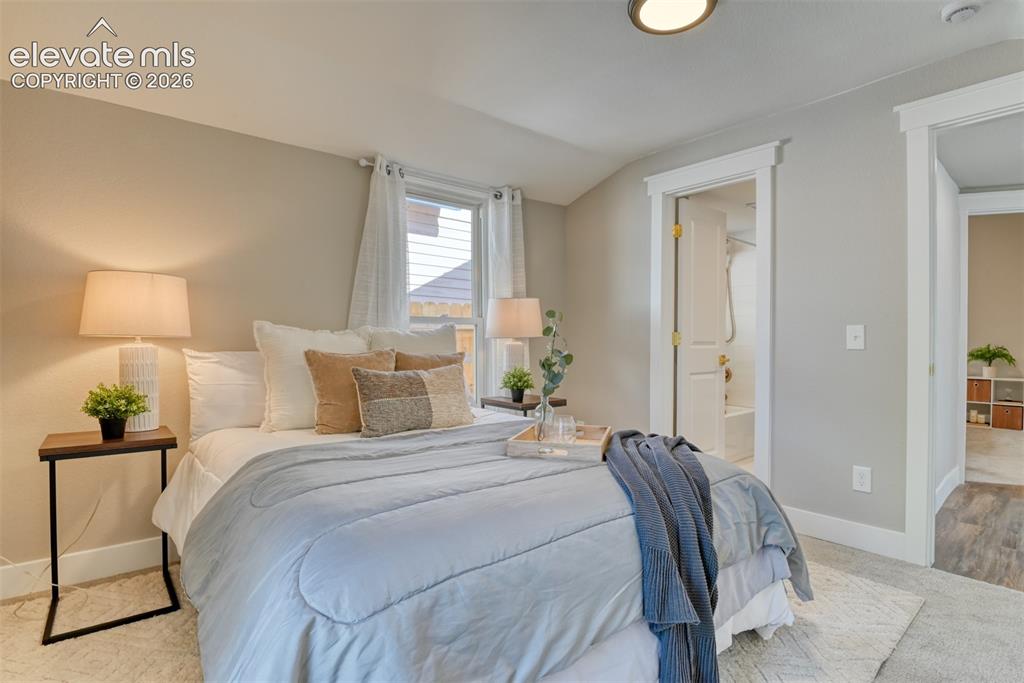 Image 34 of 47: Carpeted bedroom with a window featuring horizontal blinds and sheer drapes