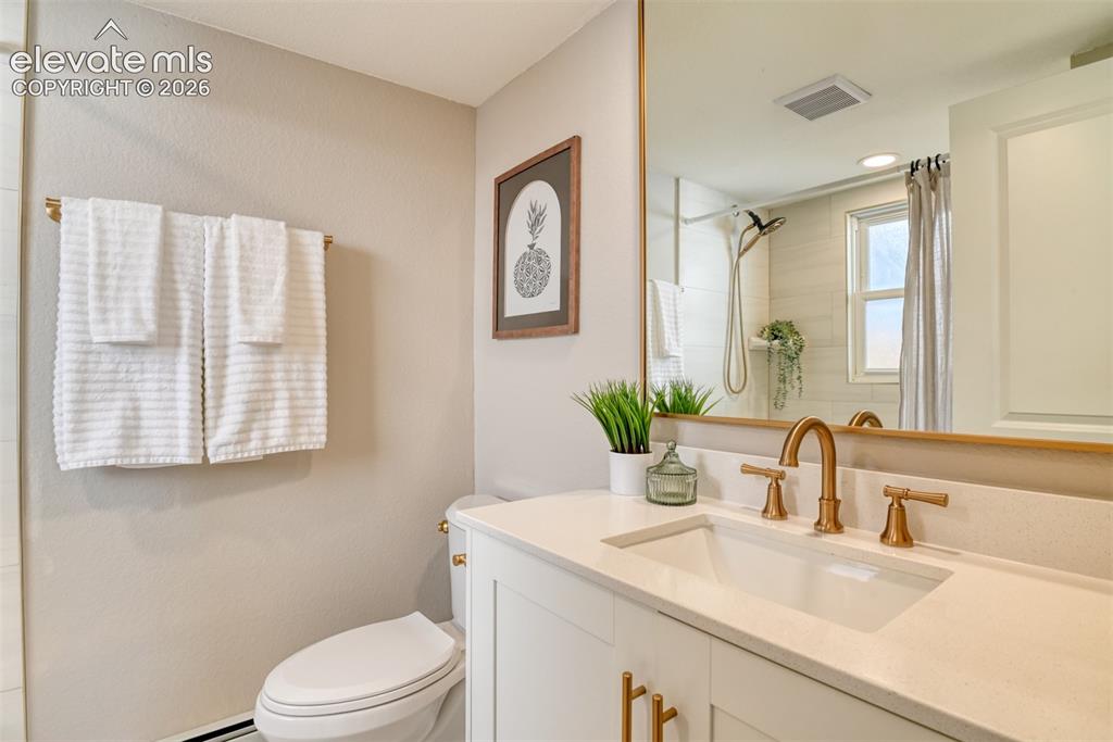 Image 37 of 47: Bathroom vanity featuring a quartz countertop and integrated sink with bras