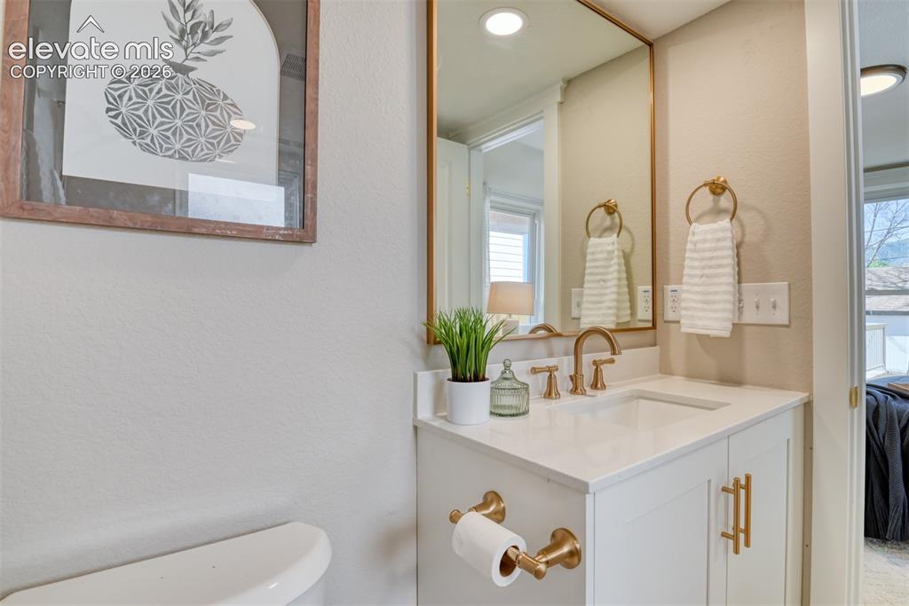 Image 38 of 47: Vanity featuring a white countertop with an integrated sink and gold-tone f