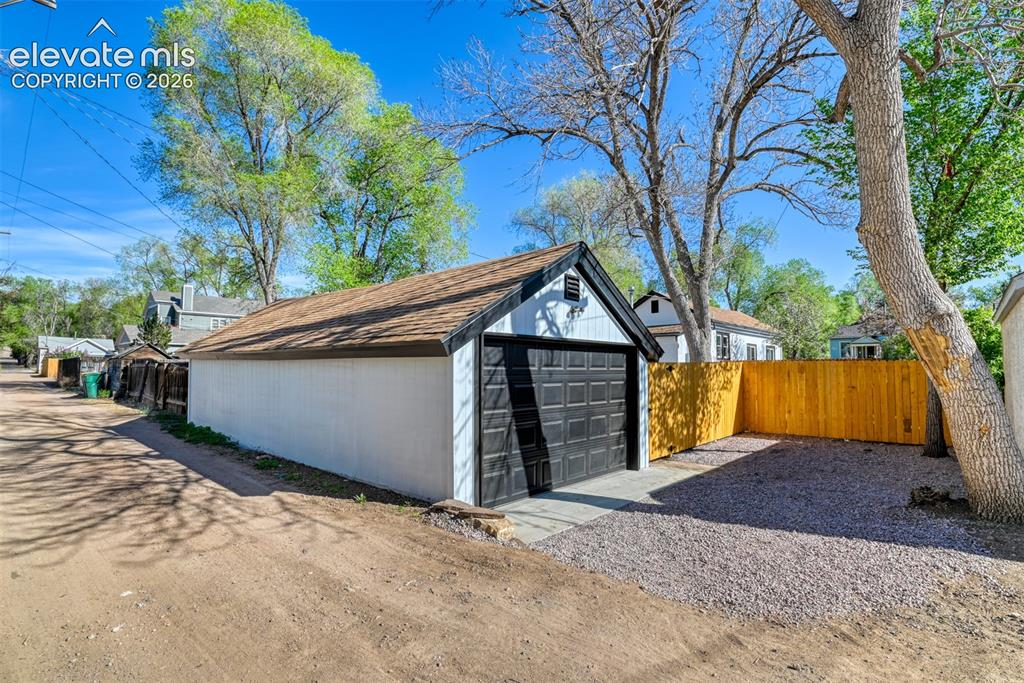Image 45 of 47: Detached garage structure featuring a single bay door and an asphalt shingl