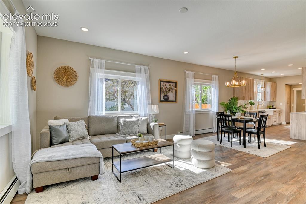 Image 8 of 47: Open-concept living and dining area featuring wood-finish flooring