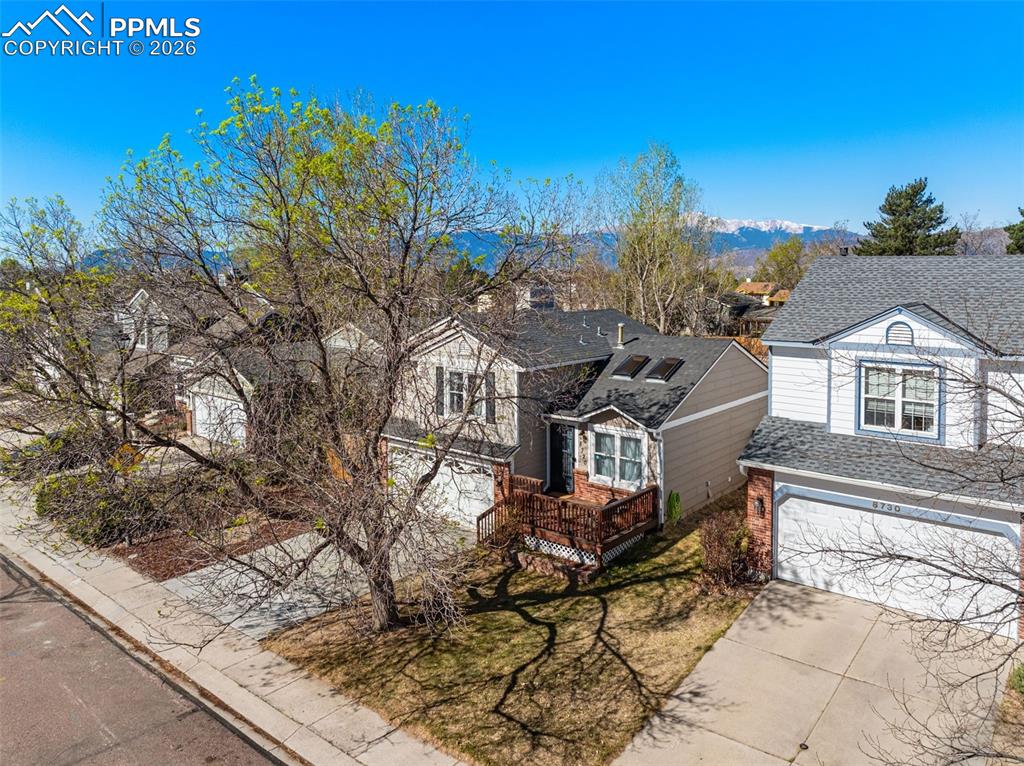 Image 10 of 50: The property features a multi-level structure with grey siding and a dark r