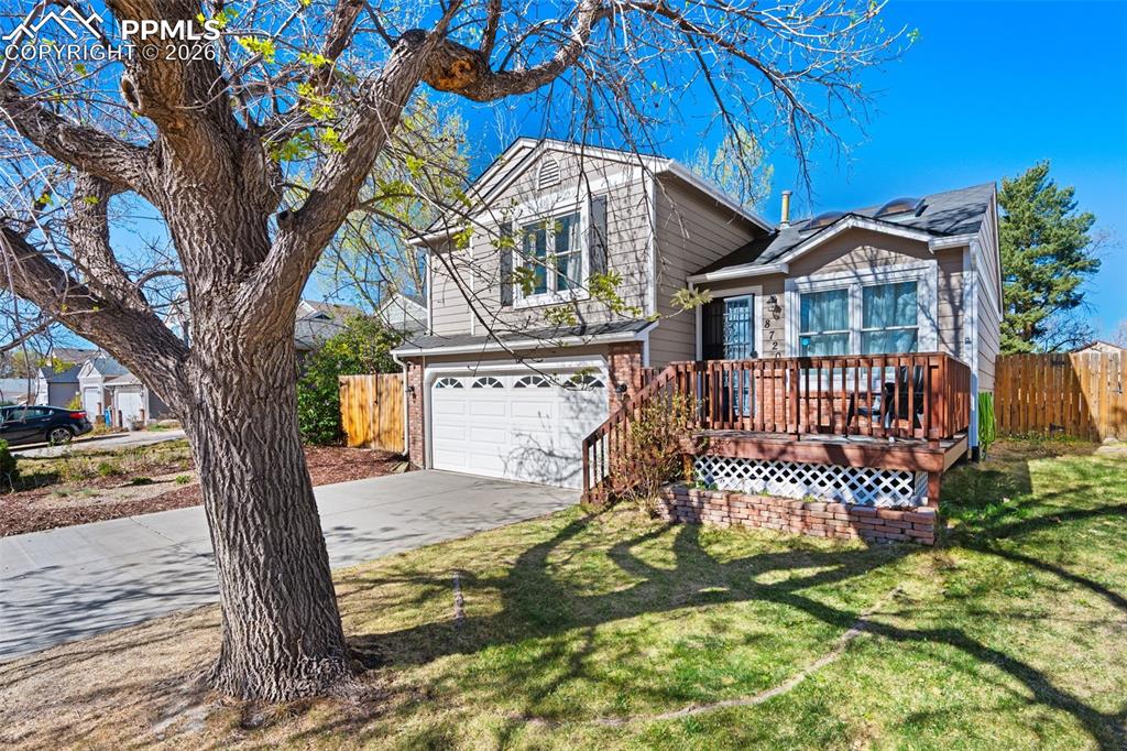 Image 13 of 50: The property features a two-car garage with a driveway, a front yard with a