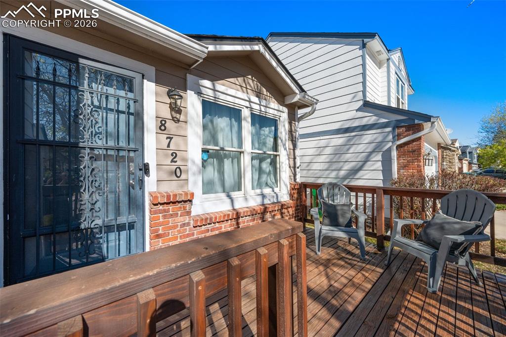 Image 14 of 50: The property features a front porch with a wooden deck and a brick facade a