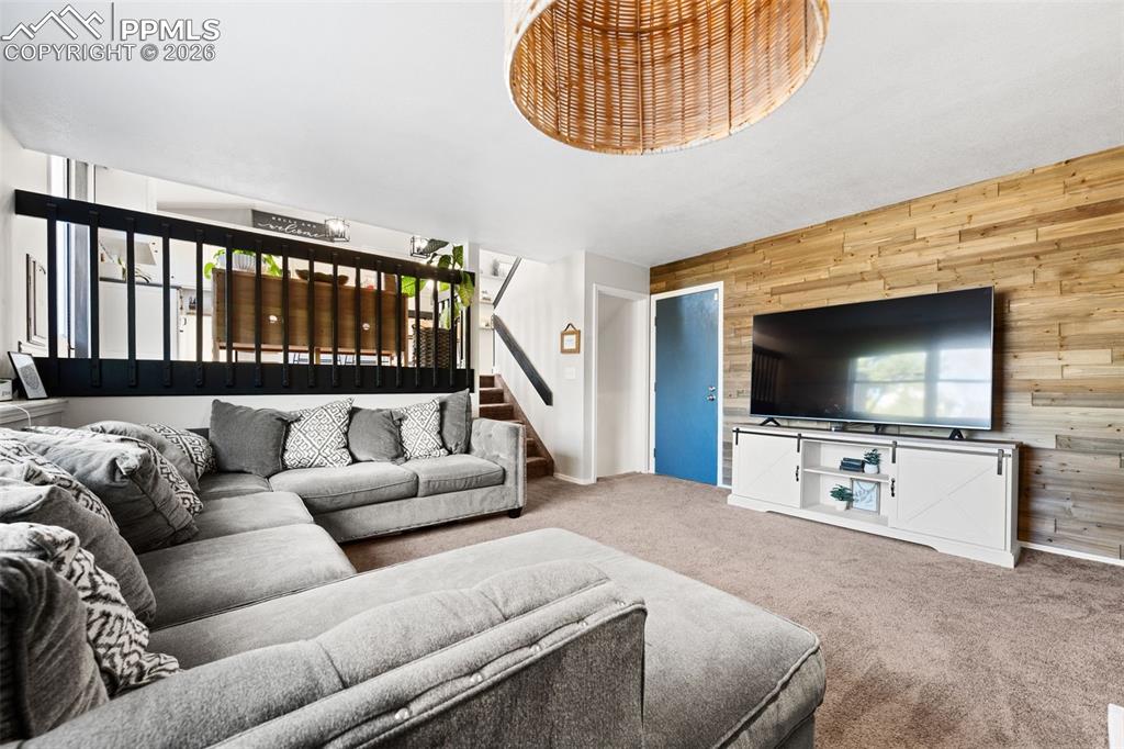 Image 22 of 50: Living area featuring a textured accent wall, an entryway with a blue door,