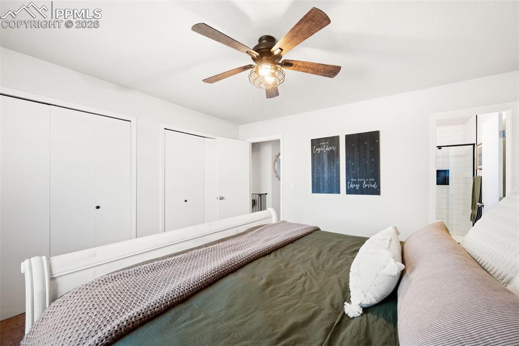 Image 25 of 50: Bedroom featuring a ceiling fan with light, white walls, and bi-fold closet
