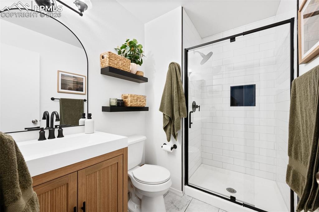 Image 26 of 50: This bathroom features a contemporary vanity with a white countertop and na