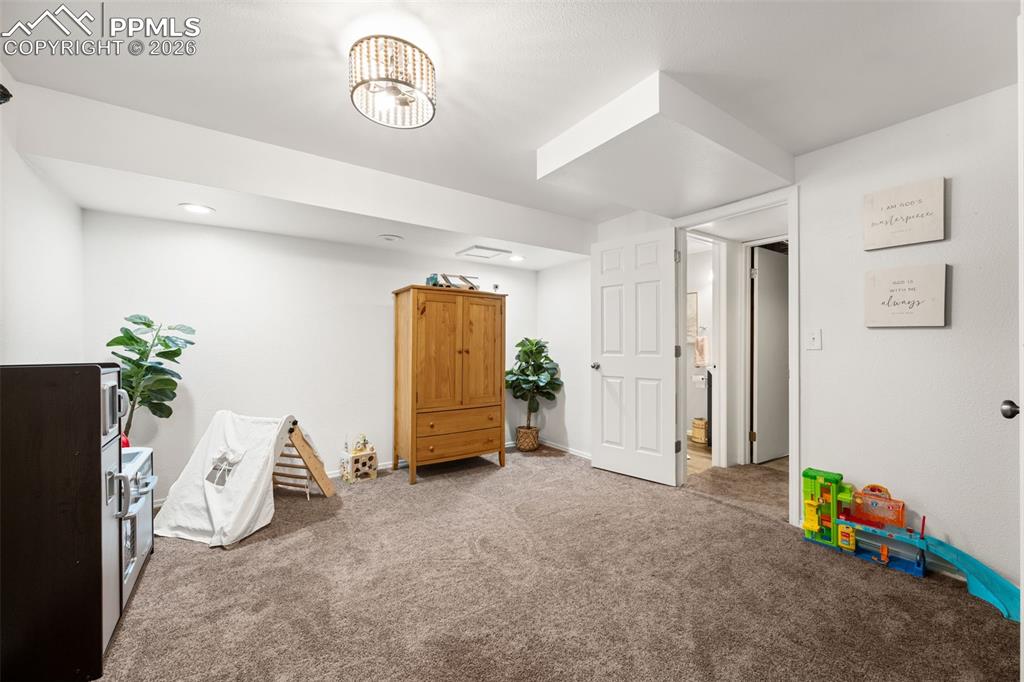 Image 34 of 50: Spacious room featuring neutral carpeting, recessed lighting, and a white p