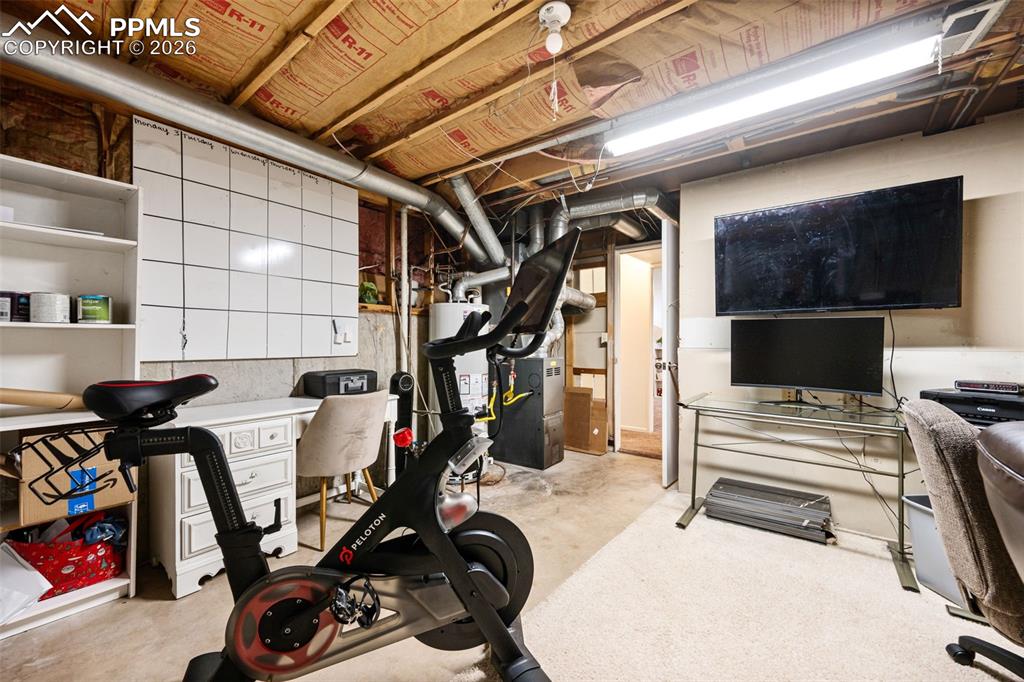 Image 37 of 50: This versatile space features exposed ceiling joists and insulation, a whit