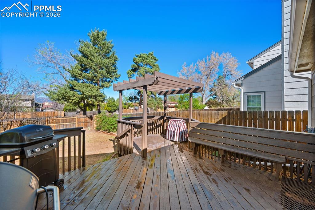 Image 38 of 50: The property features an outdoor wood deck with a pergola, built-in wooden 