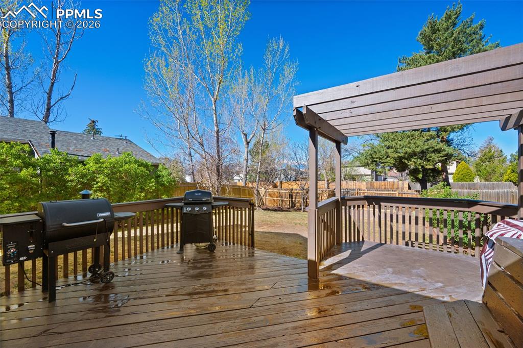 Image 39 of 50: The property features a spacious wooden deck with a slatted pergola, overlo