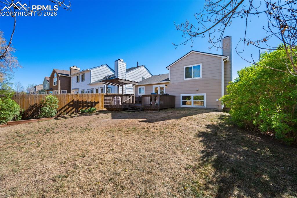 Image 42 of 50: The property features a spacious yard with a wooden fence and a multi-level