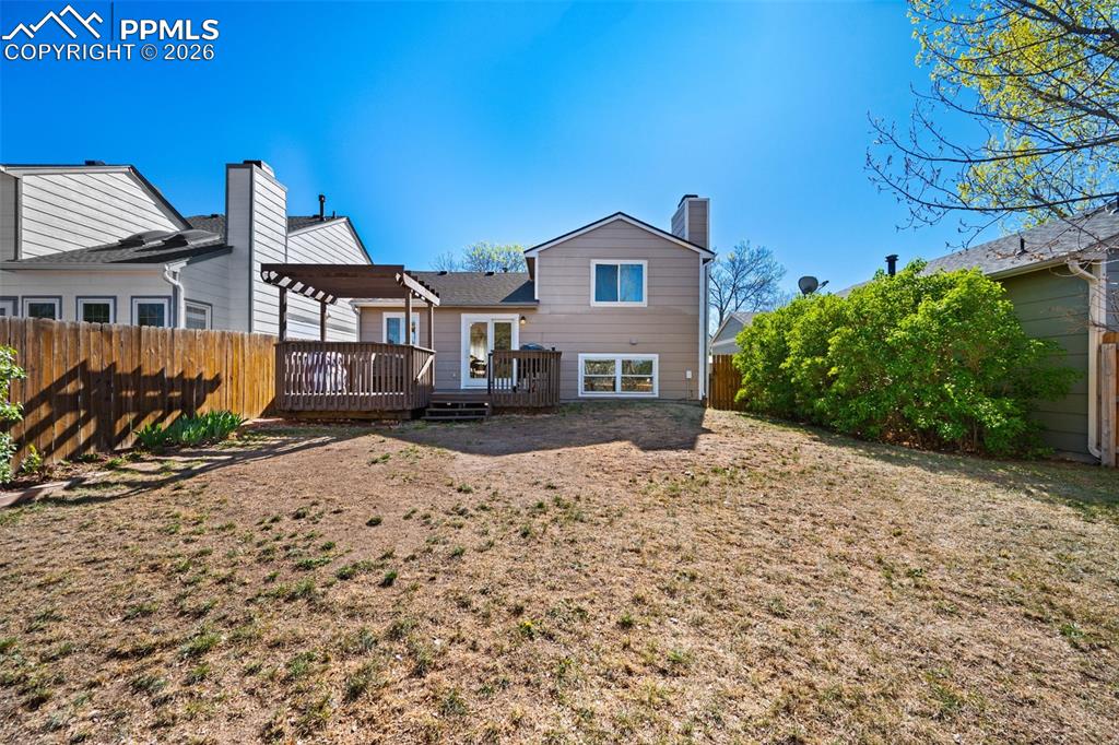 Image 43 of 50: The property features an outdoor deck with a pergola, a private backyard wi