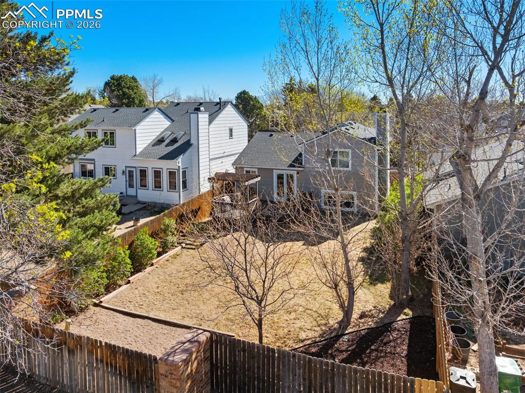 Image 44 of 50: The property features an extensive yard with a wooden fence and mature tree