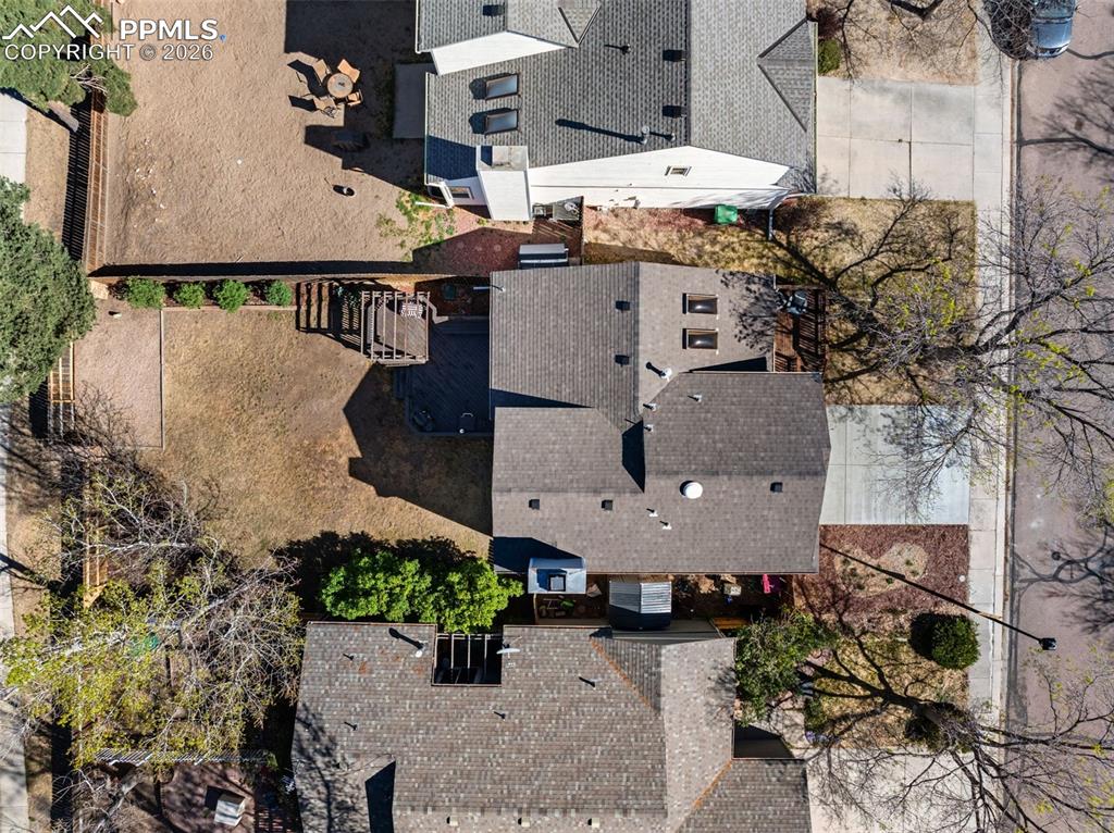 Image 46 of 50: Aerial view of the property showcasing a paved driveway, a shingle roof, an