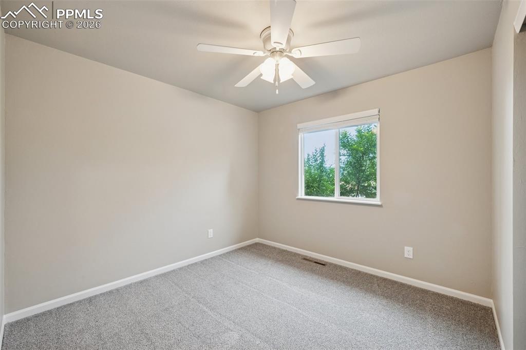 Image 16 of 34: Carpeted empty room with baseboards and ceiling fan