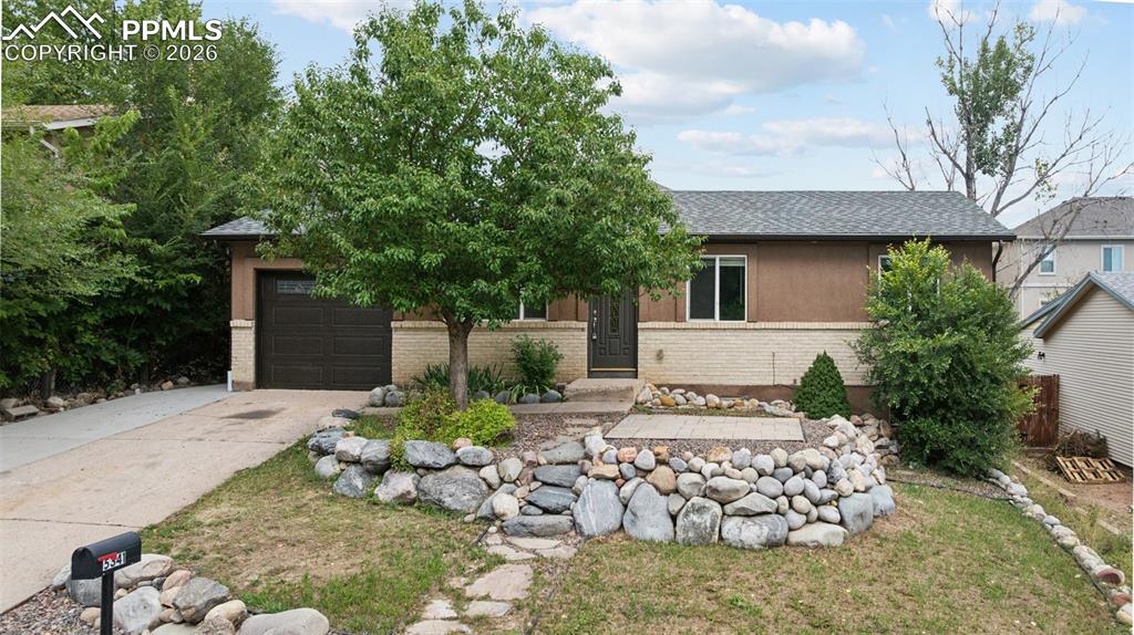 Image 2 of 34: View of front facade with brick siding, roof with shingles, concrete drivew