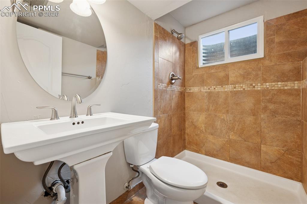 Image 21 of 34: Bathroom featuring toilet and a tile shower