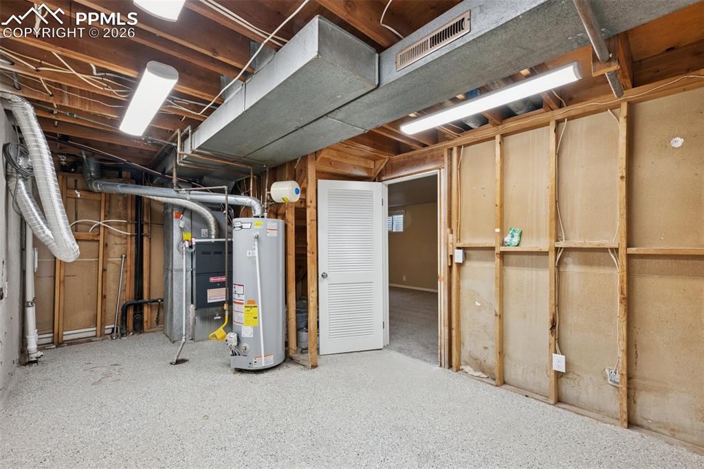 Image 29 of 34: Unfinished basement featuring gas water heater and heating unit
