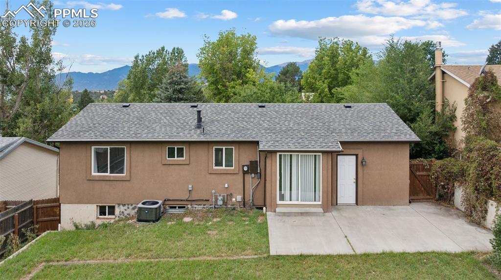 Image 31 of 34: Rear view of property featuring a shingled roof, a mountain view, a patio a