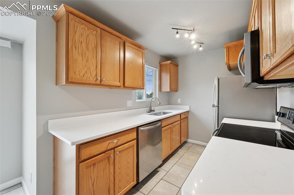Image 4 of 34: Kitchen featuring light countertops, stainless steel appliances, light tile