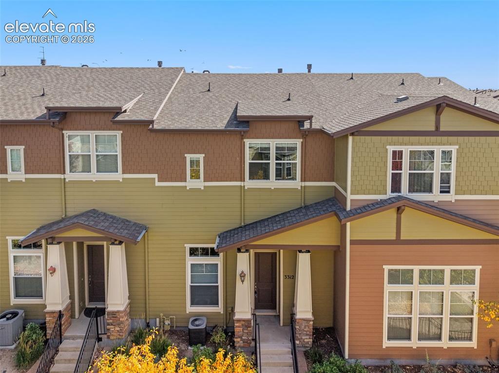 Caption: Contemporary townhome community featuring multiple units with varied exterior finishes in warm earth