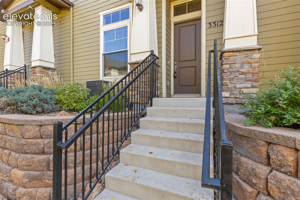 Image 10 of 44: Concrete entry stairs with wrought iron railings