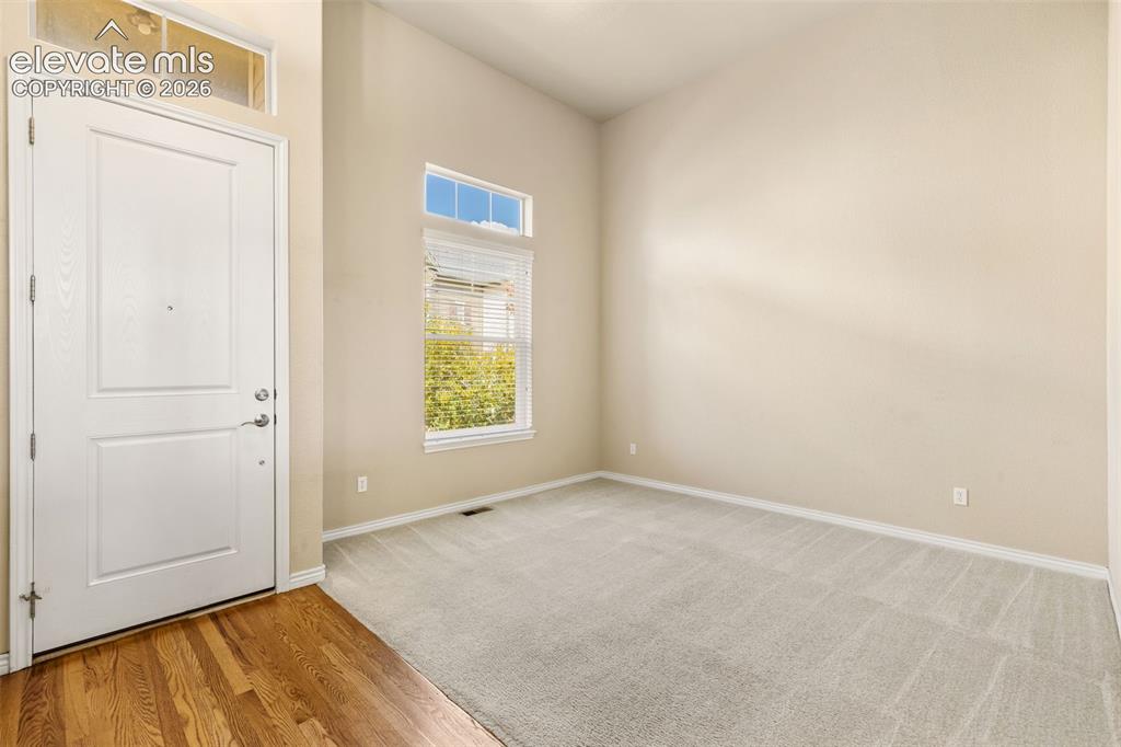 Image 12 of 44: Vaulted ceiling, wood-finish flooring, light carpet, transom windows, and a