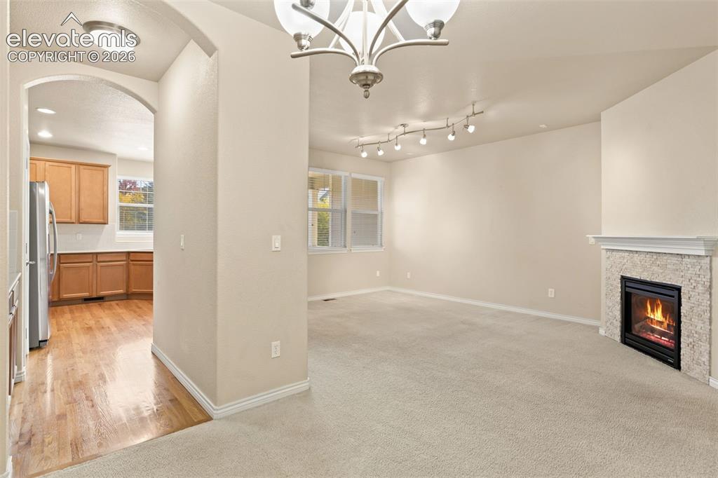 Image 18 of 44: Spacious living area featuring soaring ceilings with recessed and track lig