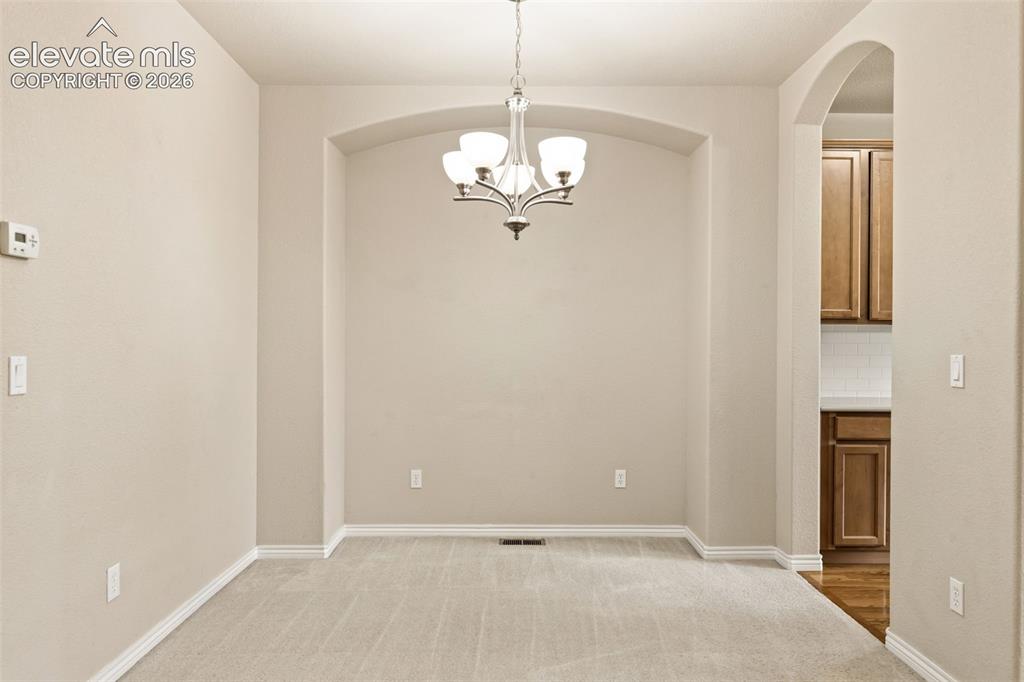Image 19 of 44: Spacious formal dining room featuring an arched ceiling with crown molding,
