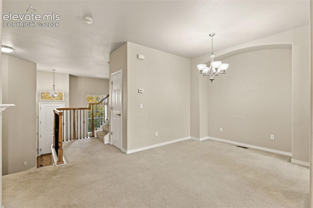 Image 20 of 44: Carpeted flooring throughout, arched wall niche, and chandelier lighting fi