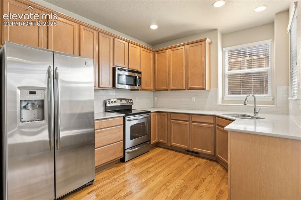 Image 27 of 44: Kitchen featuring stainless steel appliances, wood-finish flooring, recesse