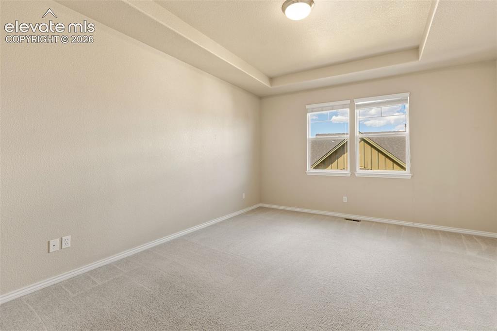 Image 32 of 44: Recessed ceiling details, dual windows, neutral wall color, and light-color