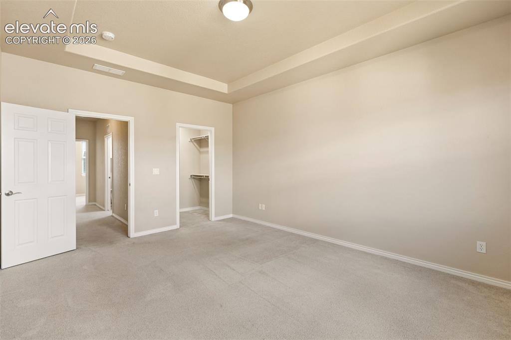 Image 34 of 44: Recessed ceiling accent, carpeted flooring, and built-in closet shelving