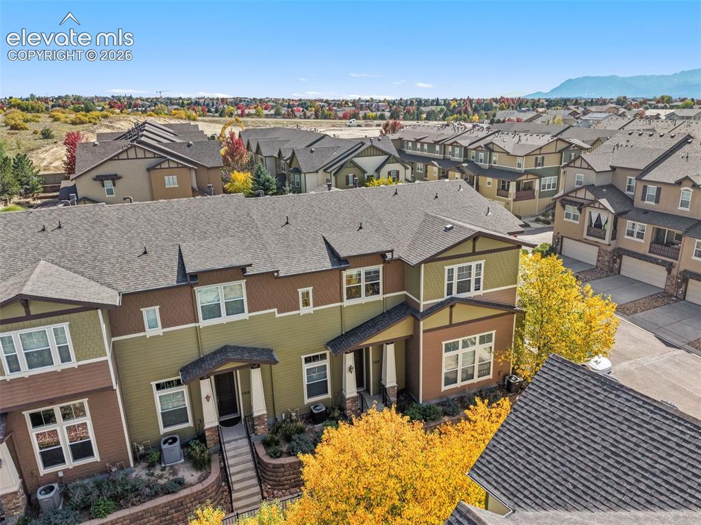 Image 4 of 44: Multi-level townhome exterior featuring an attached garage, landscaped entr