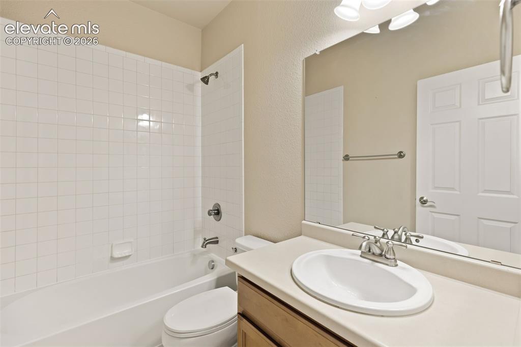 Image 40 of 44: Bathroom featuring a vanity with an oval sink, broad mirror, and overhead l