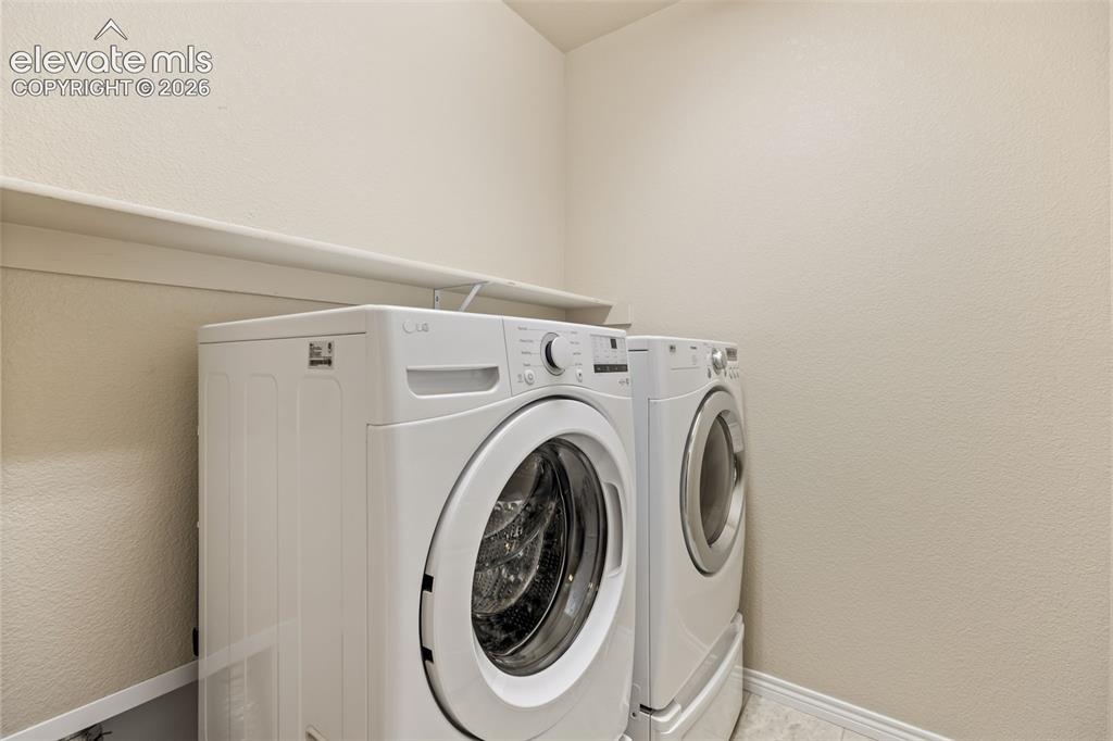 Image 44 of 44: Laundry area featuring a built-in shelf, textured walls, and base molding