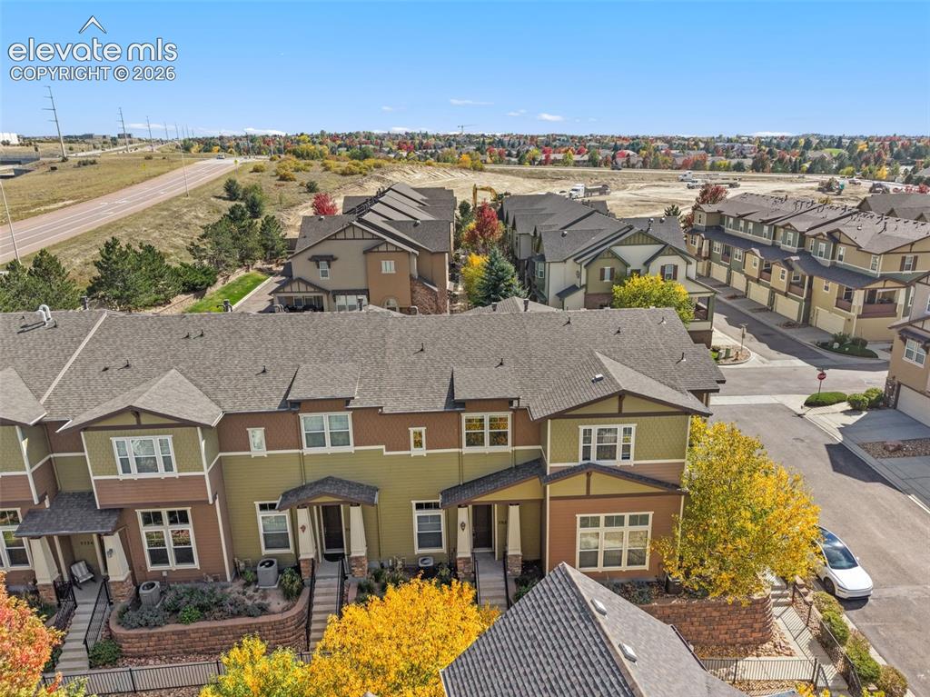 Image 5 of 44: Multi-level townhome architecture with a shingle roof and contrasting sidin