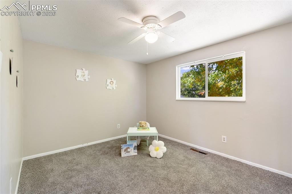Image 15 of 29: Carpeted empty room featuring a ceiling fan and a textured ceiling