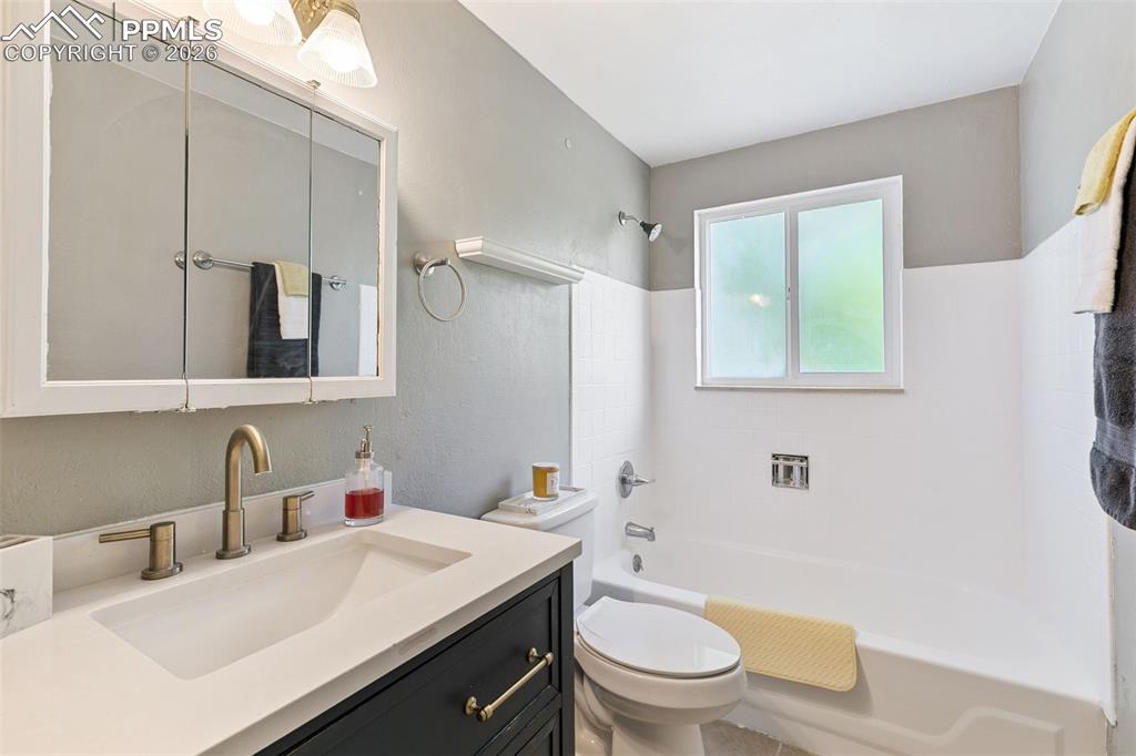 Image 16 of 29: Bathroom featuring vanity, shower / washtub combination, and a textured wal