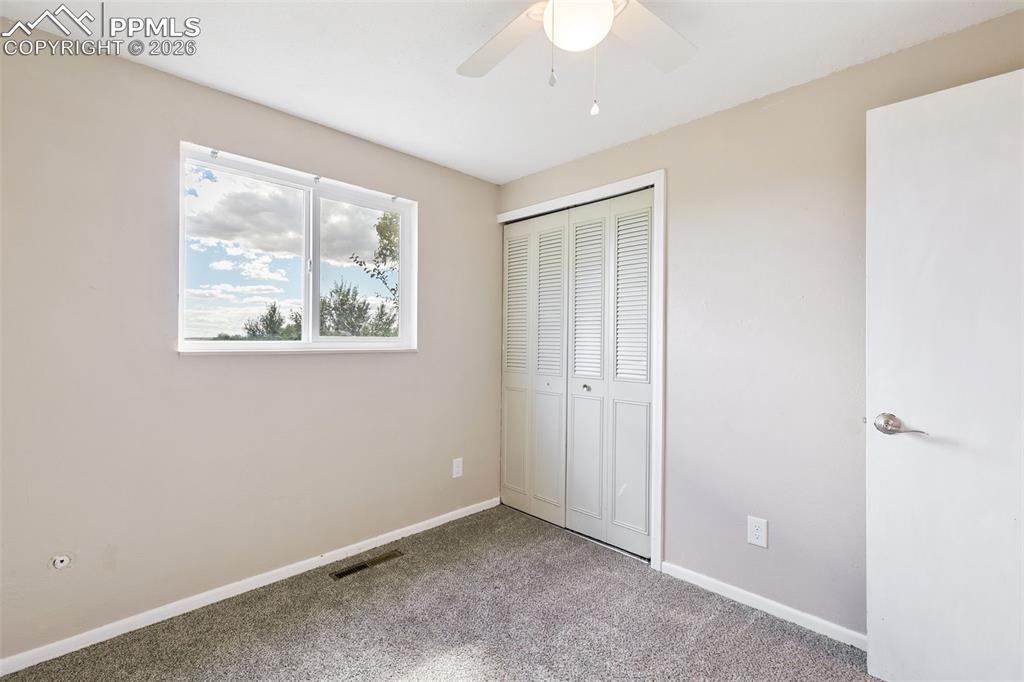 Image 19 of 29: Unfurnished bedroom with a closet, ceiling fan, and carpet