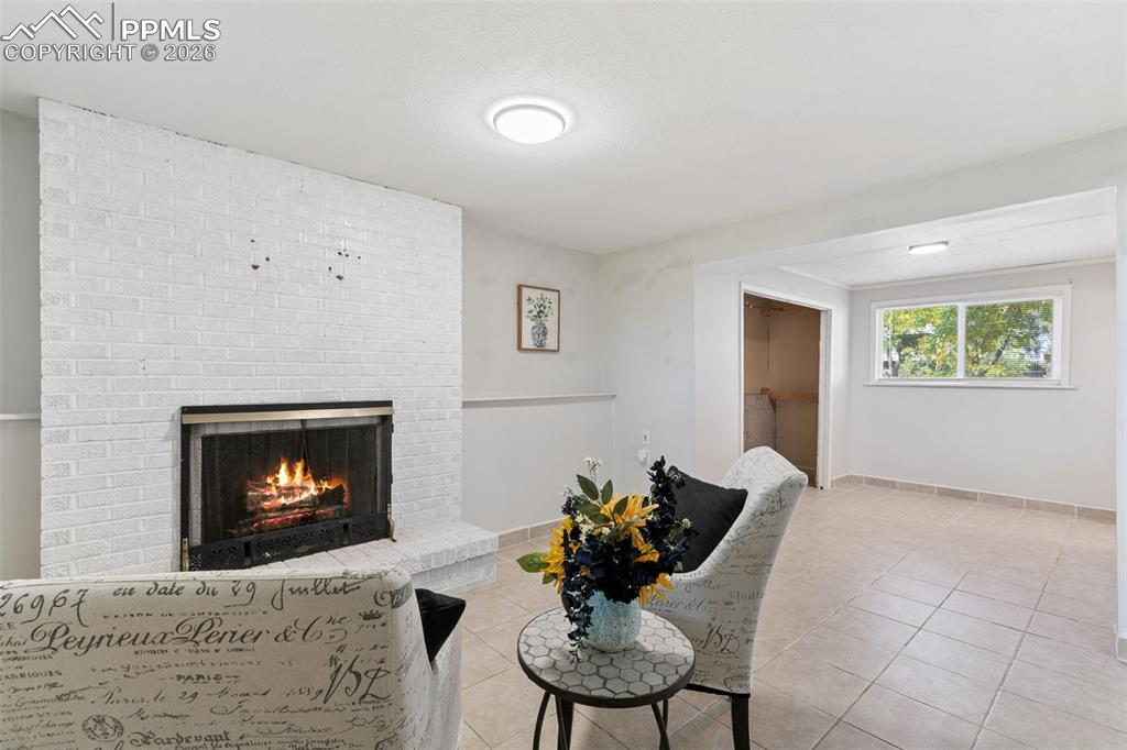 Image 23 of 29: Tiled living area with a fireplace