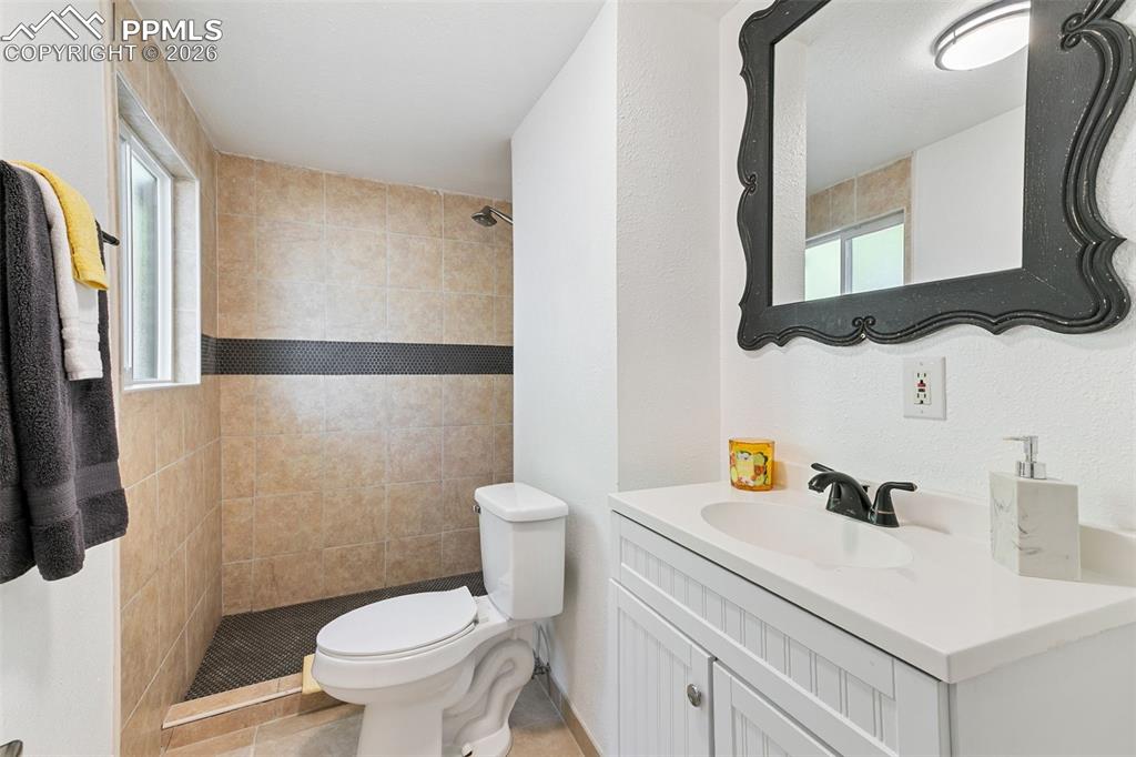 Image 25 of 29: Full bath with vanity, a stall shower, healthy amount of natural light, and