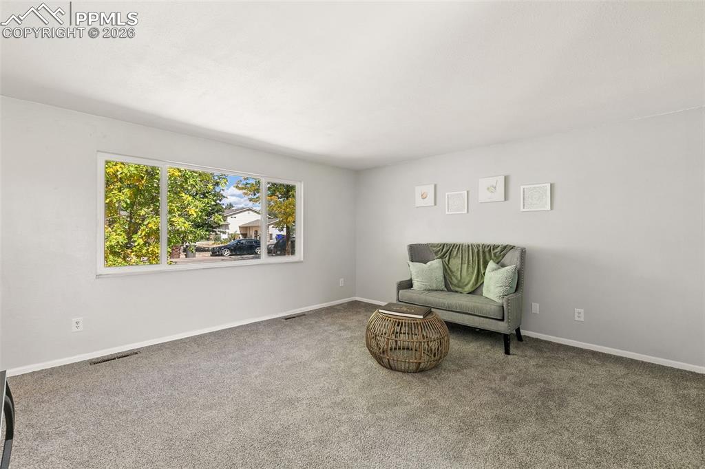 Image 7 of 29: Living area featuring carpet floors and baseboards